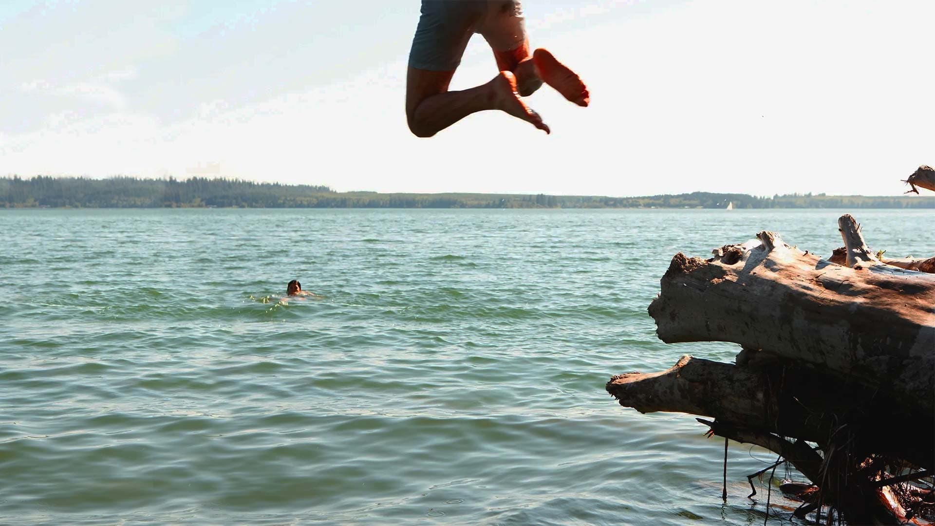Person jumping into a mountain lake
