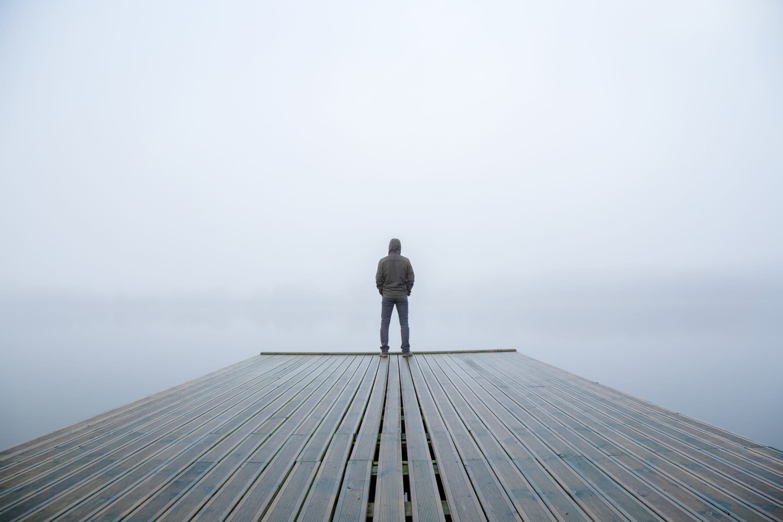 young,man,standing,alone,on,edge,of,footbridge,and,staring